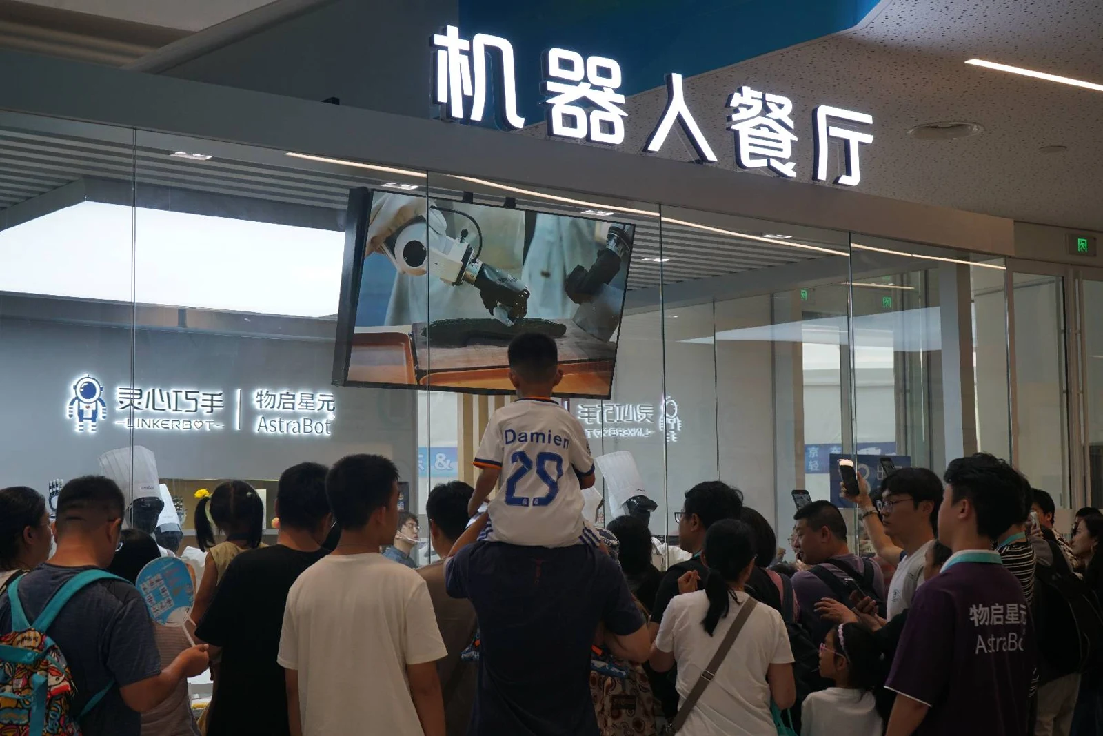 冰丝带机器人餐厅现场，观众观看机器人烹饪